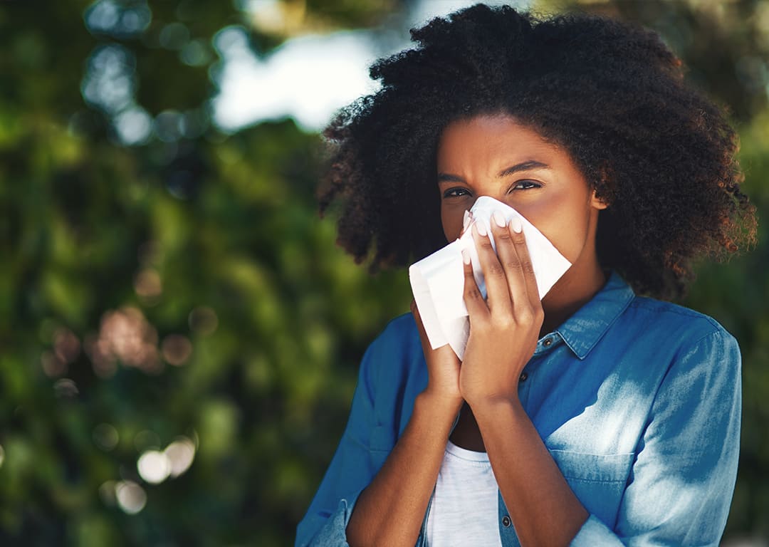 woman blowing nose into a tissue